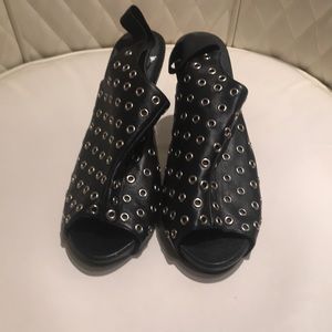 Black platform sandals with silver circle details.